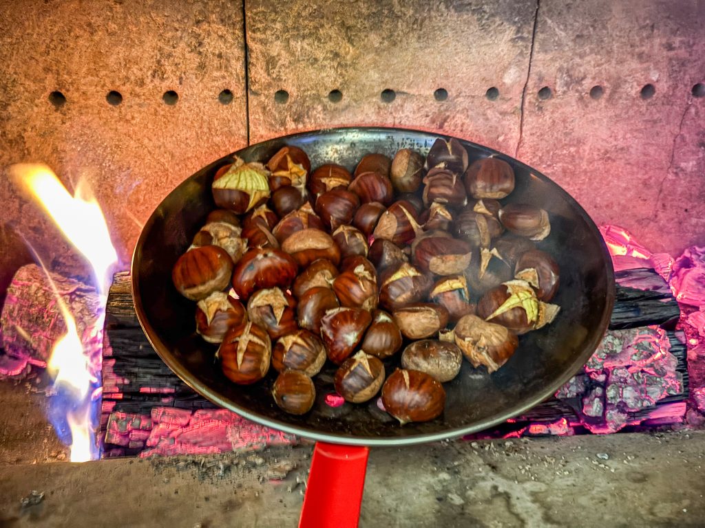 Castanyes rostint-se al foc en una paella sobre brases